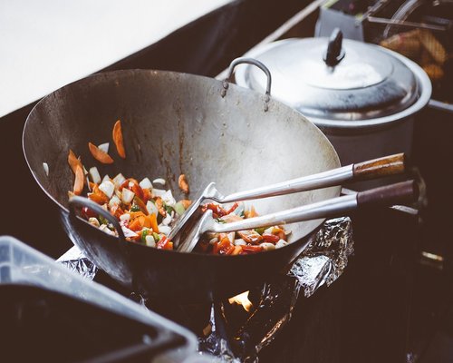 Garlic sizzling in hot oil in an iron wok pan